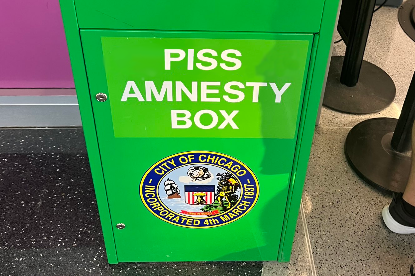 A tall green box, like those currently used for cannabis amnesty, but "Piss Amnesty" is written on the front instead of "Cannabis Amnesty"